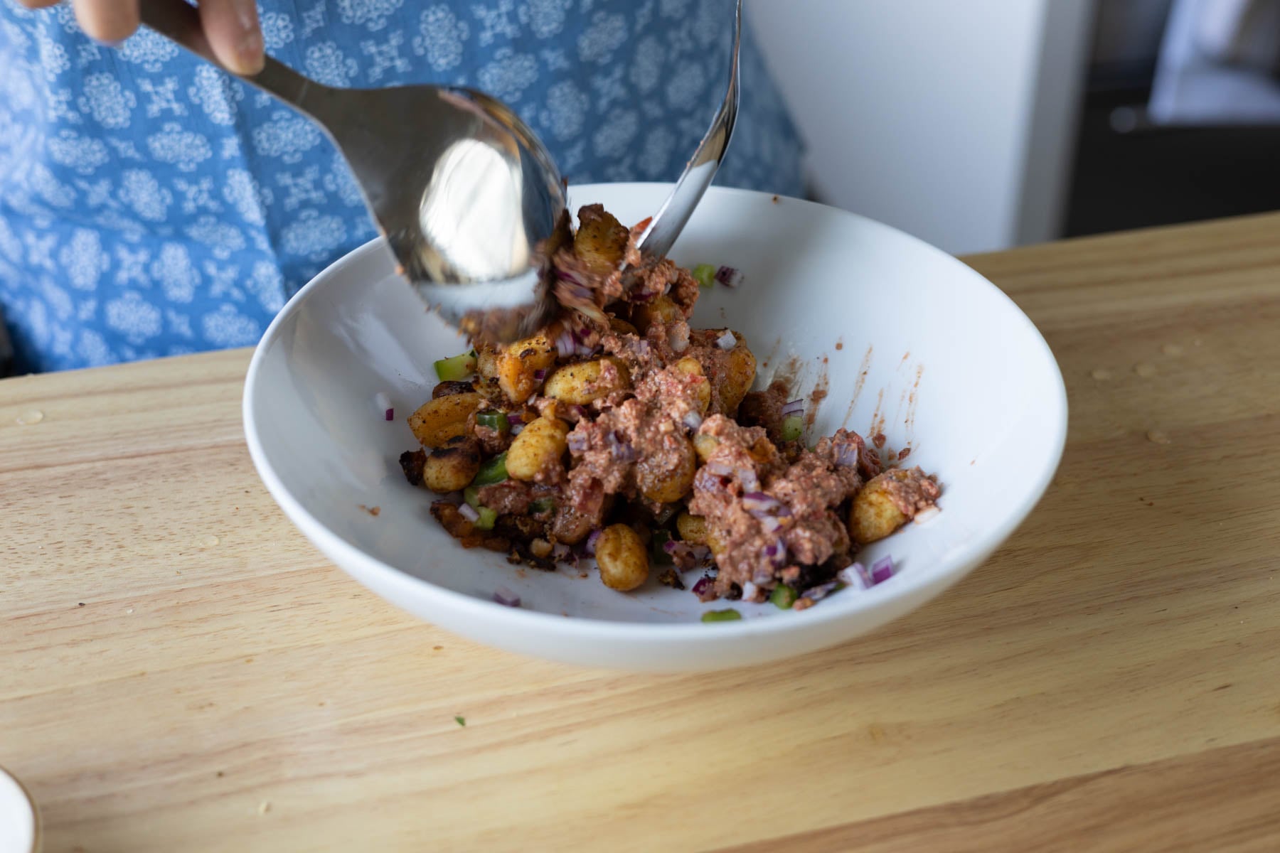 tossing the gnocchi, beans, and veggies with the bean dip and lemon juice