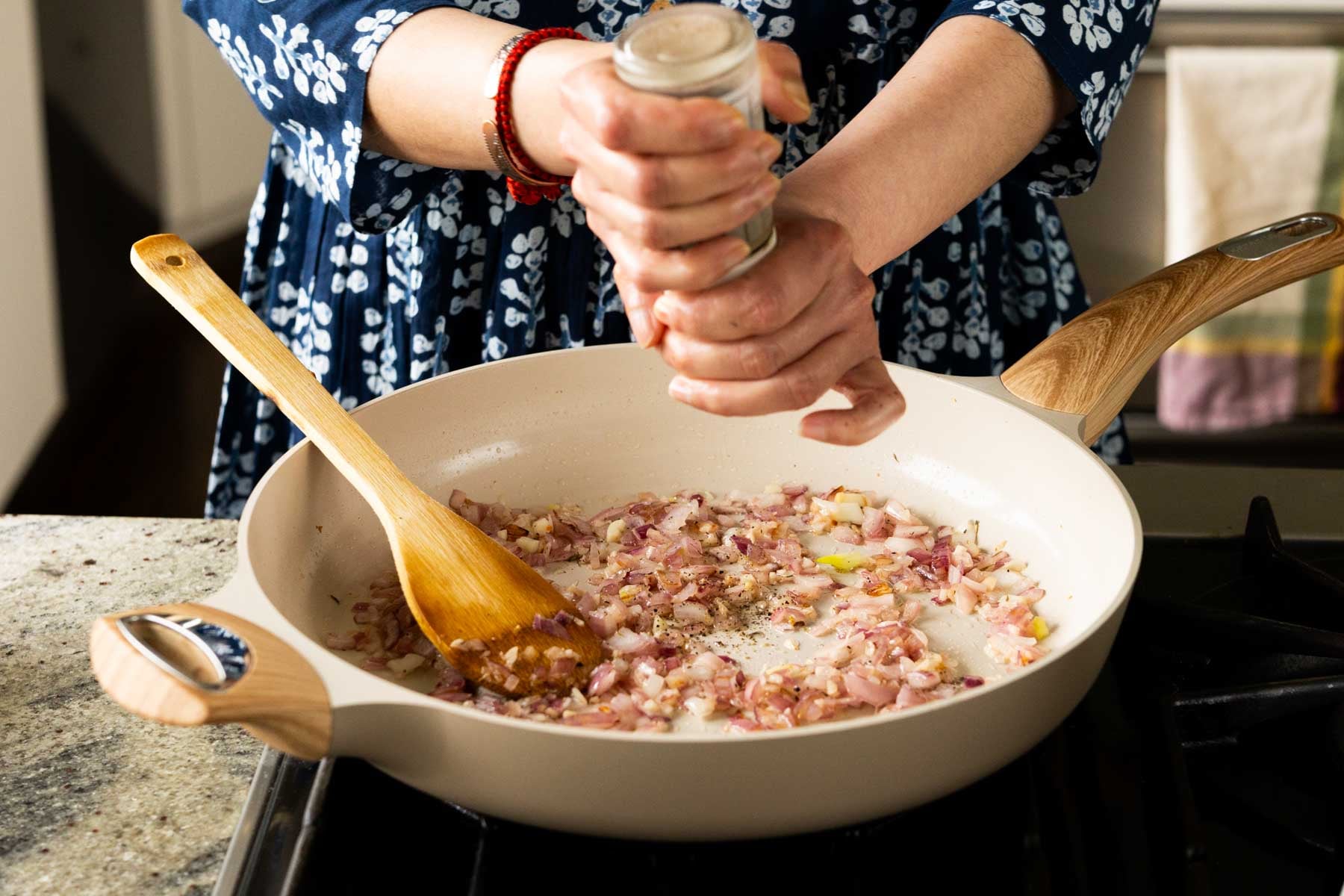 adding black pepper to the pan