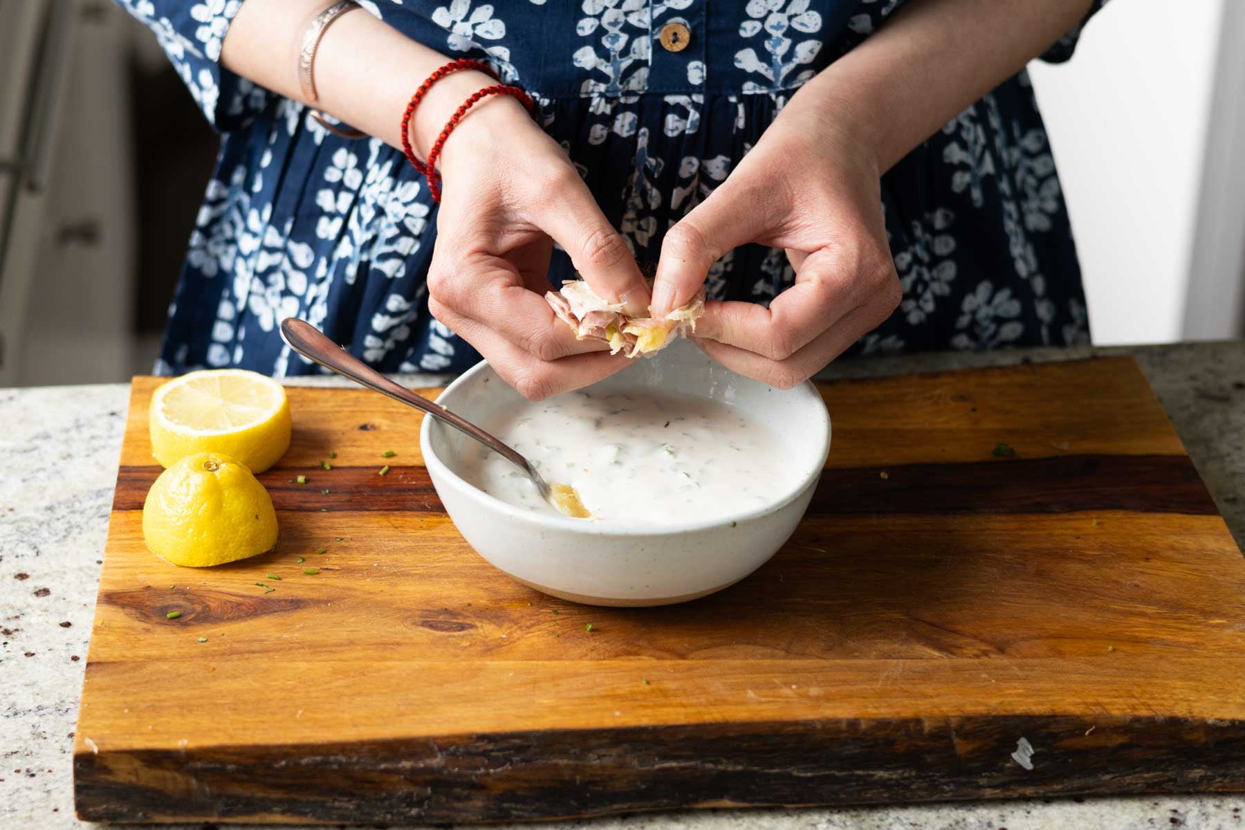 adding the roasted garlic to the yogurt sauce