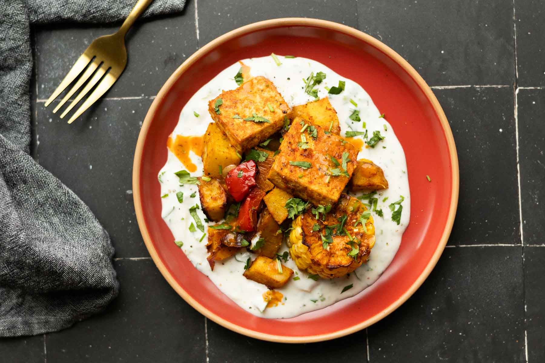 peri-peri tofu and vegetables on a bed of the yogurt sauce