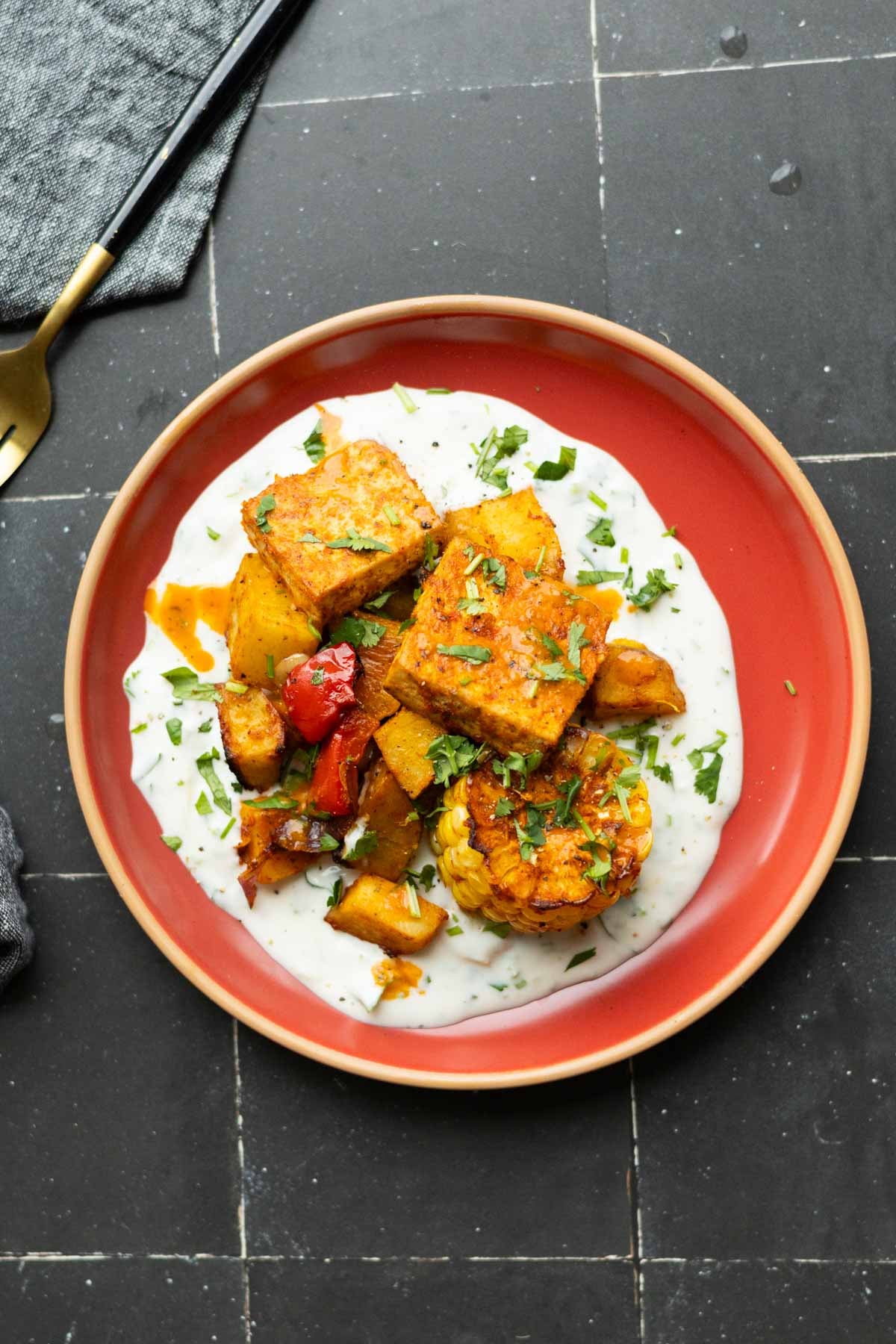 peri-peri tofu and vegetables on a bed of the yogurt sauce