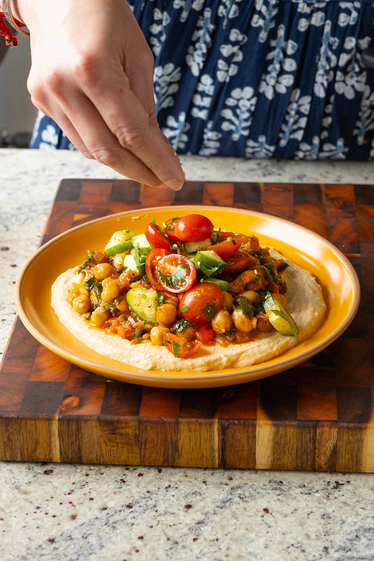 sprinkling sesame seeds onto the peri peri chickpeas platter