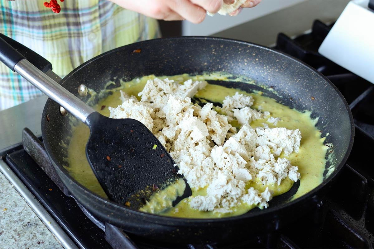crumbling tofu into the skillet