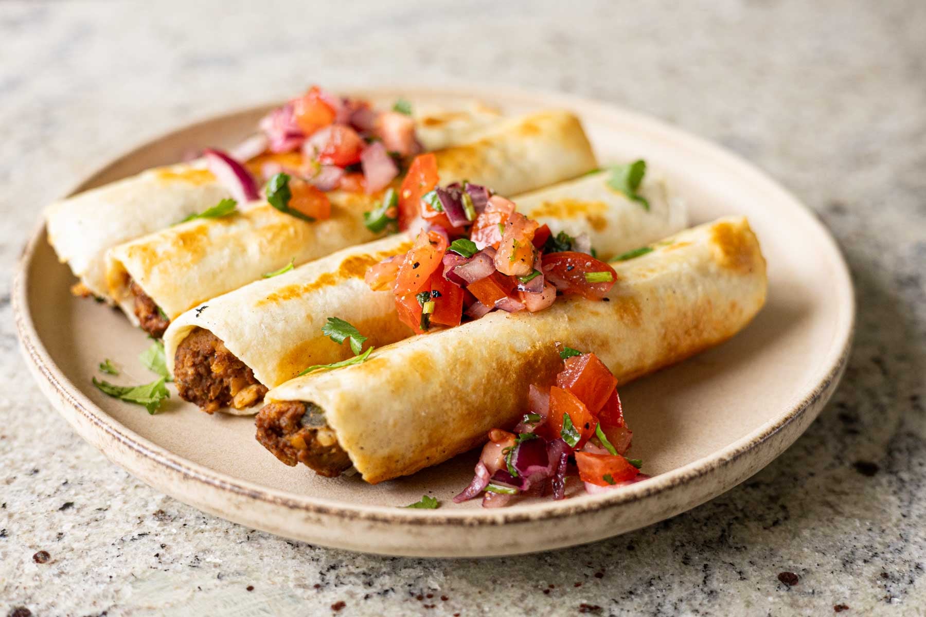 chickpea mushroom taquitos on a plate with pico de gallo