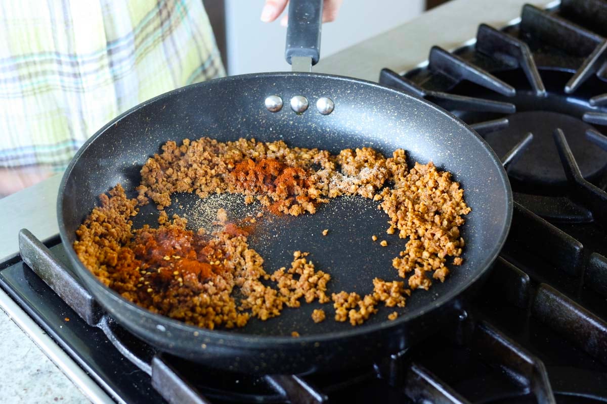 adding veggie grounds and spices to the pan