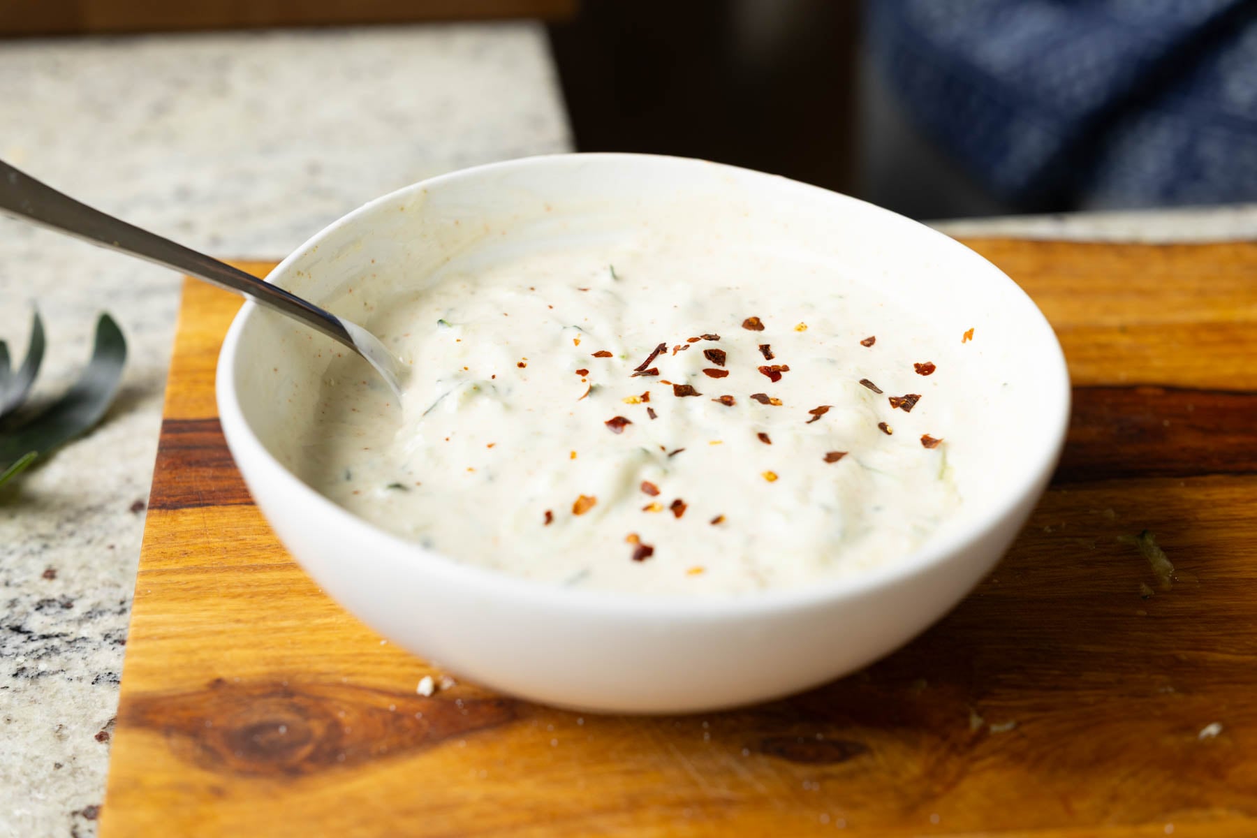topping the raita with crushed pepper