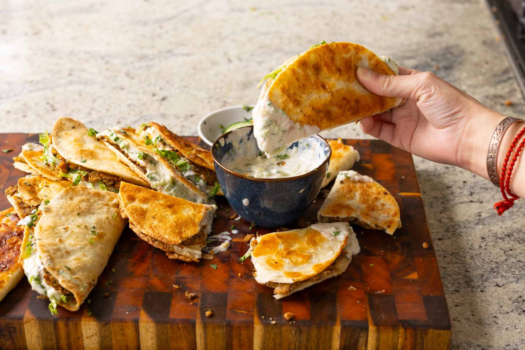 dipping a paratha taco into raita