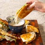 dipping a paratha taco into raita