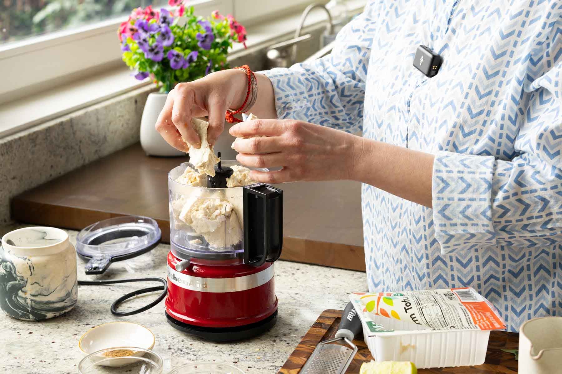 adding whipped tofu ingredients to the food processor
