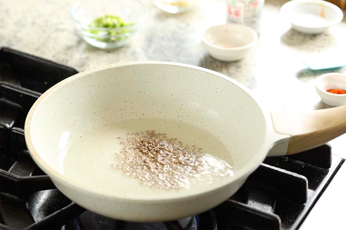 adding cumin seeds to the pan