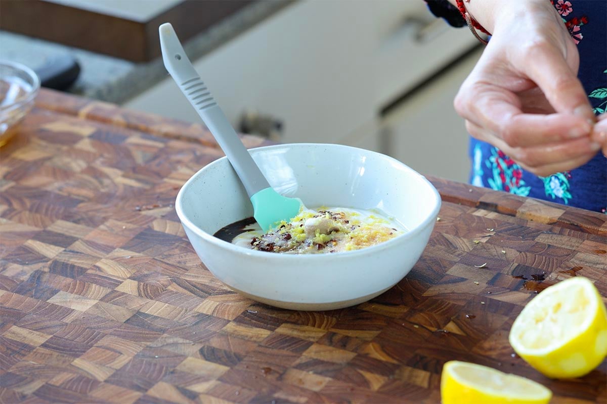 adding dressing ingredients to the bowl