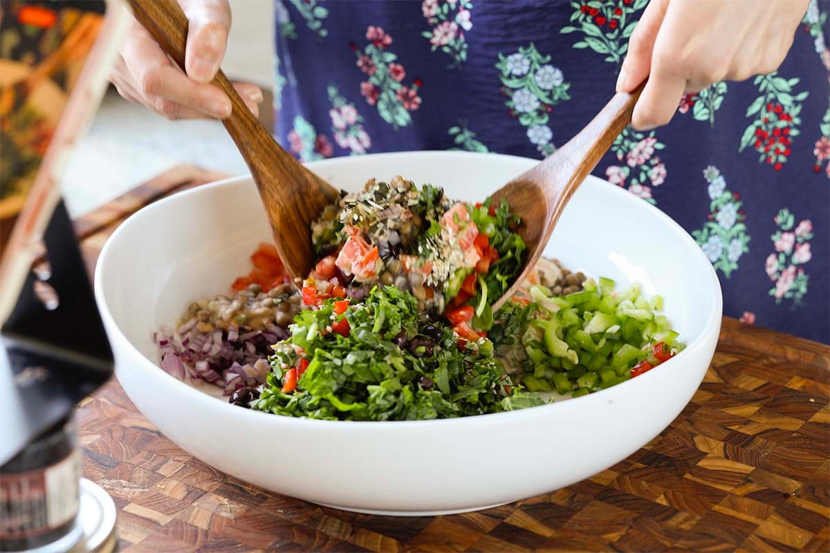 tossing the dense bean salad together