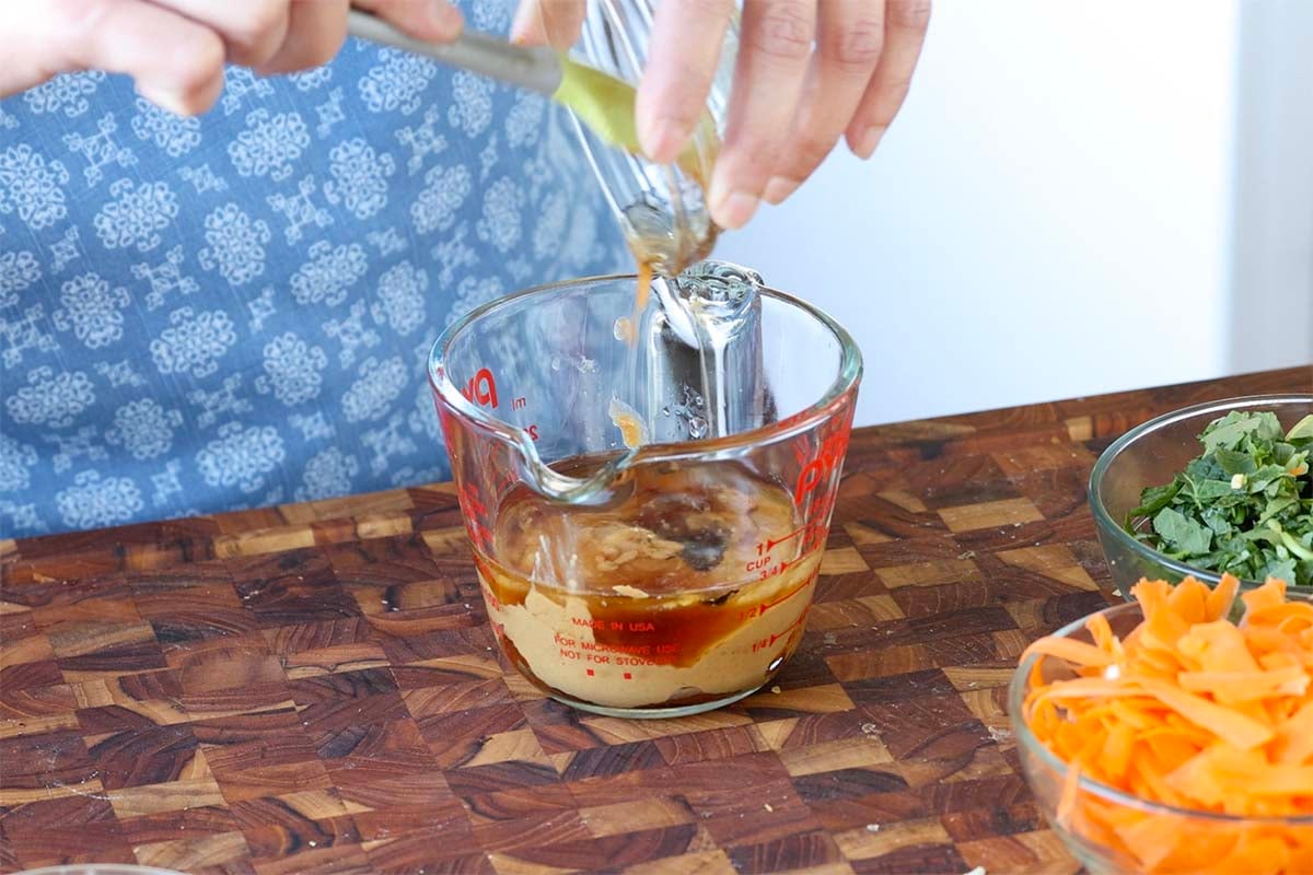 adding dressing ingredients to a bowl