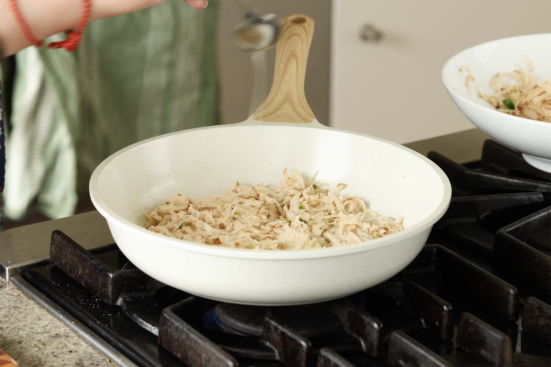 adding the potatoes to the pan