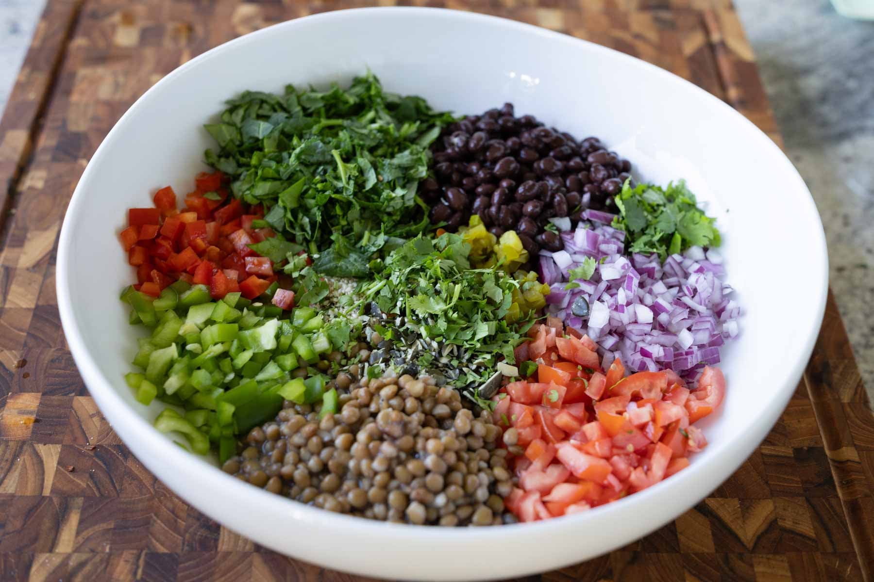 dense bean salad ingredients in the bowl before adding the dressing