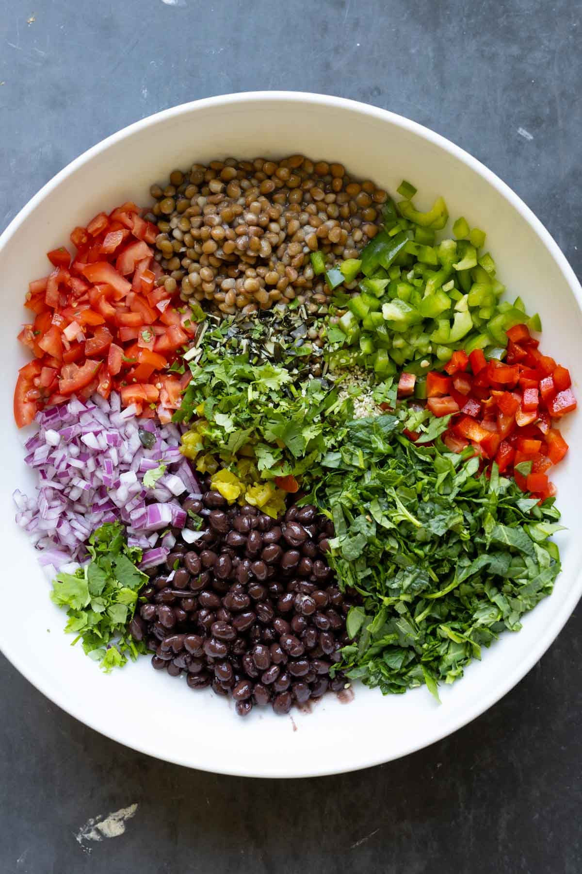 dense bean salad ingredients in the bowl before adding the dressing