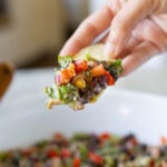tortilla chip scooping up some dense bean salad