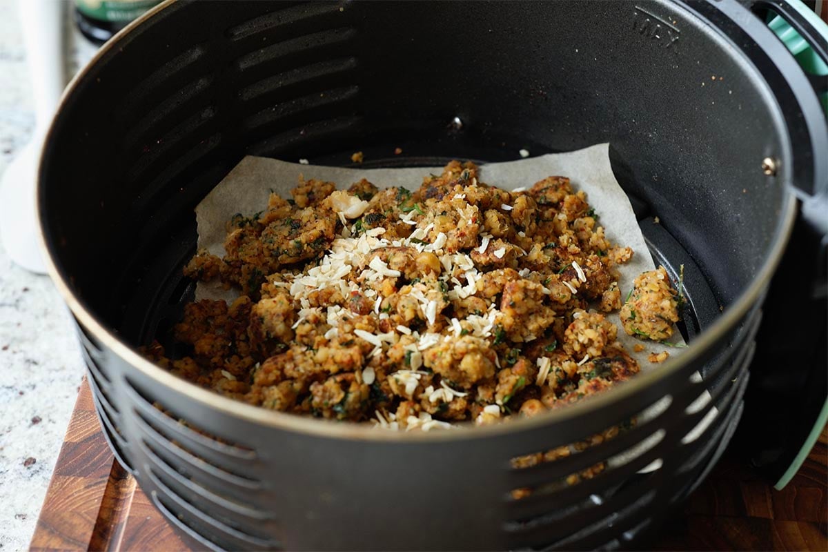adding onion flakes to the chickpea toping in the food processor
