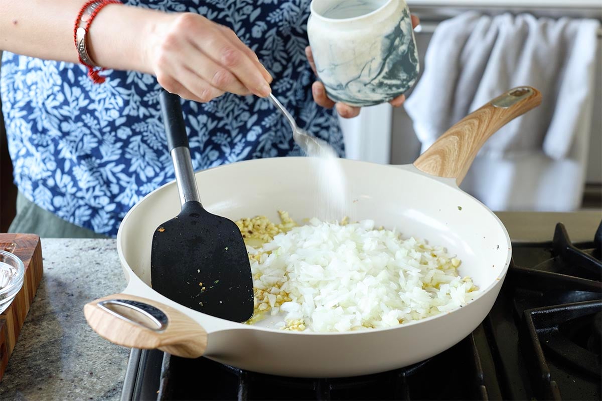 adding onions and salt to the pan