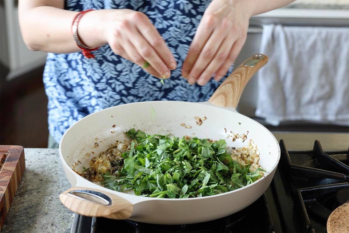 adding the greens to the pan
