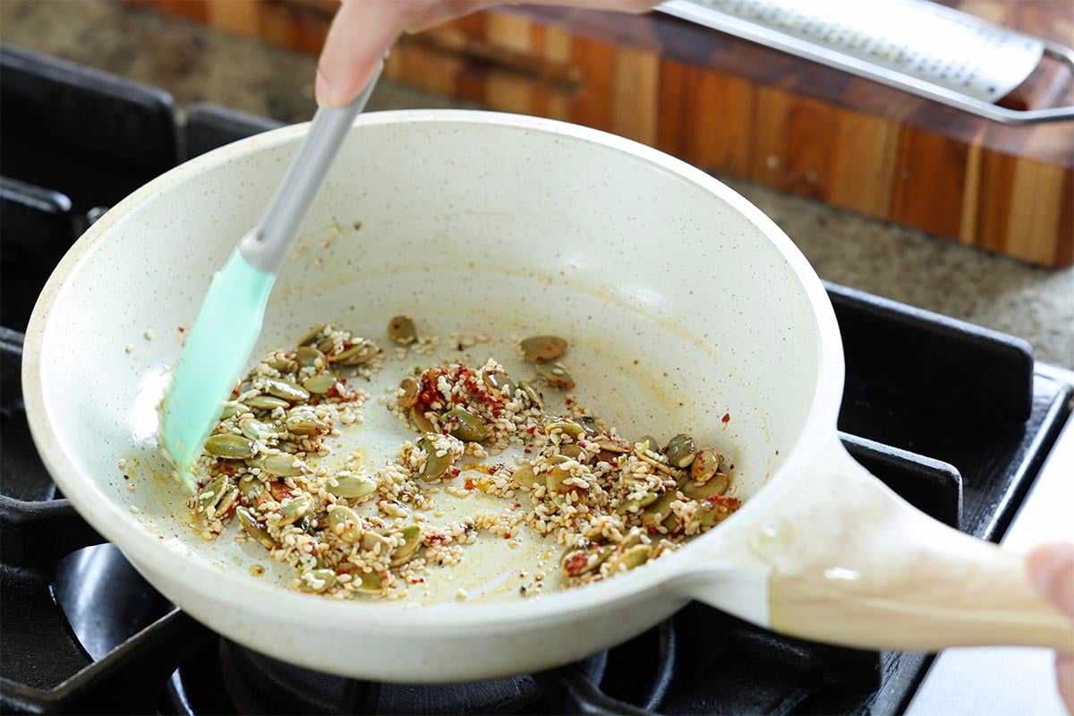 mixing pepper flakes and lemon zest into the seeds