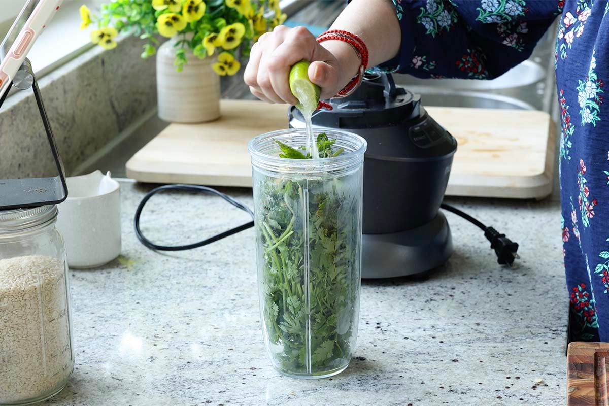 adding green chutney ingredients to the blender