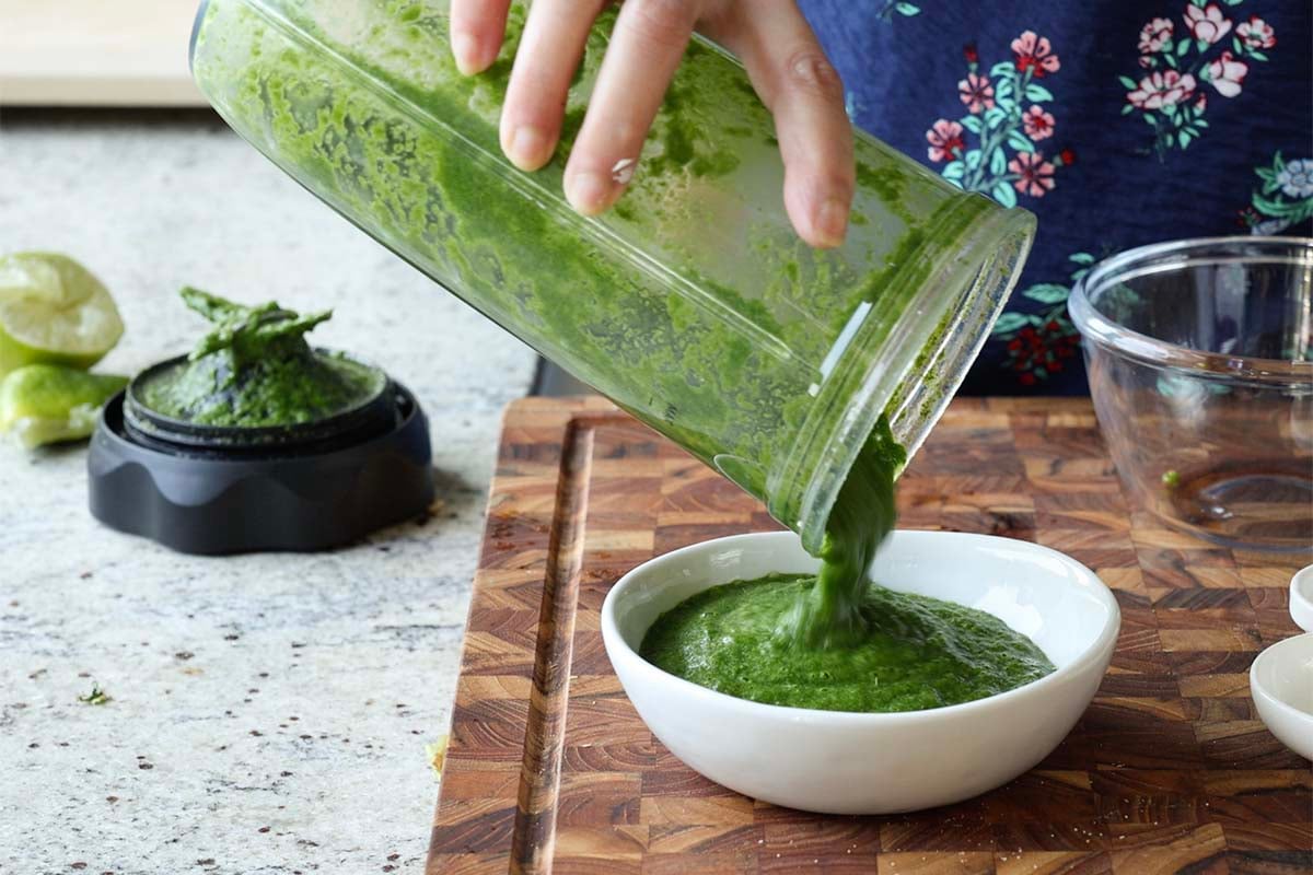 pouring green chutney into a bowl