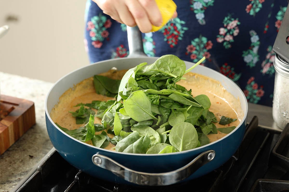 adding spinach to the pan