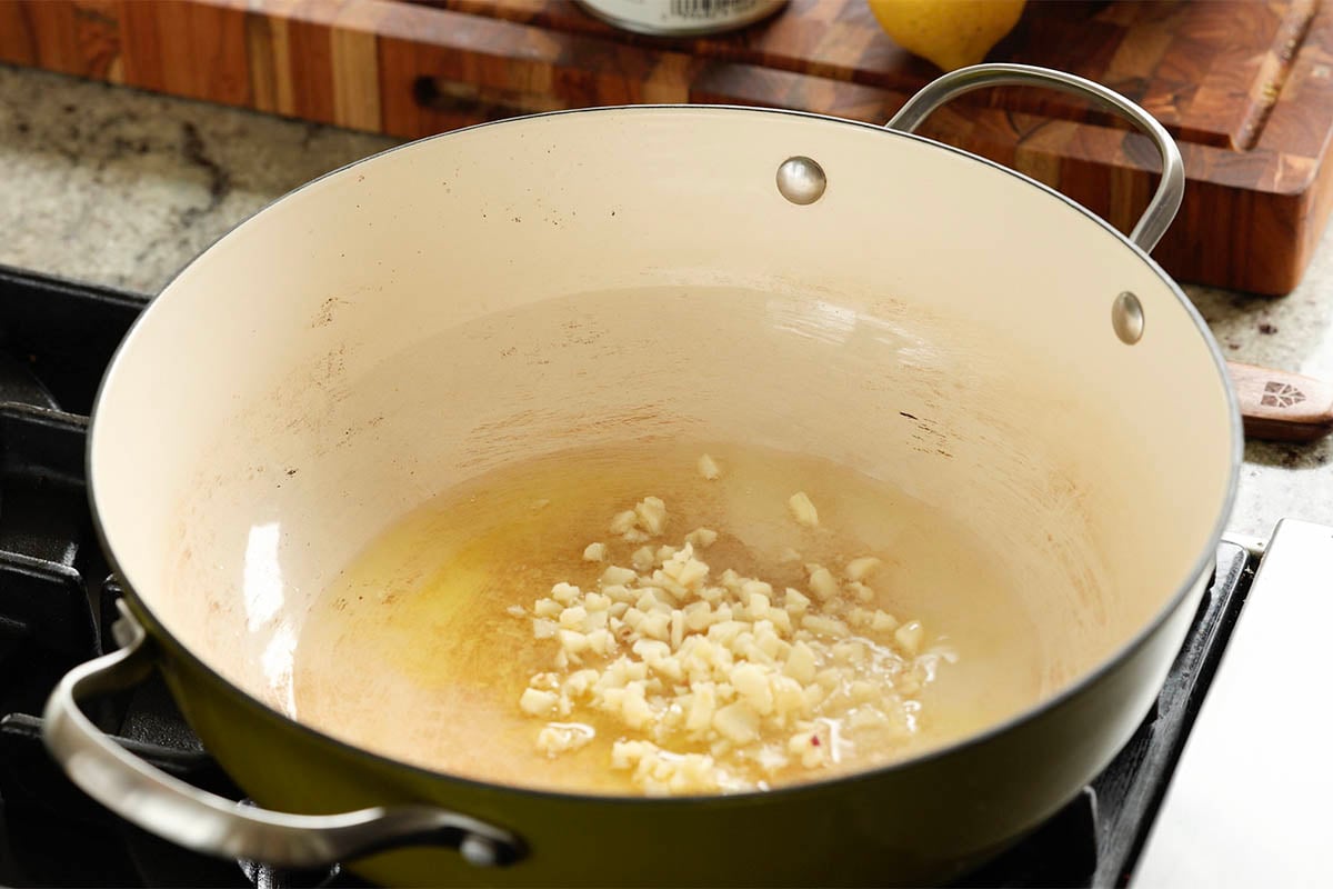 adding garlic to the pan