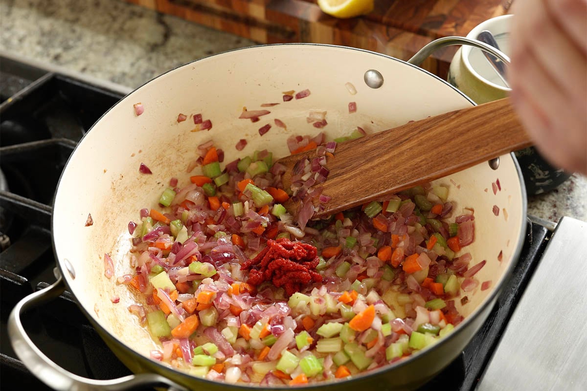 adding tomato paste to the pan