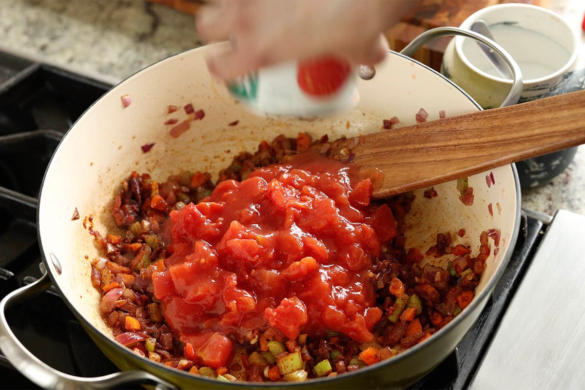 adding ginger and tomato to the pan
