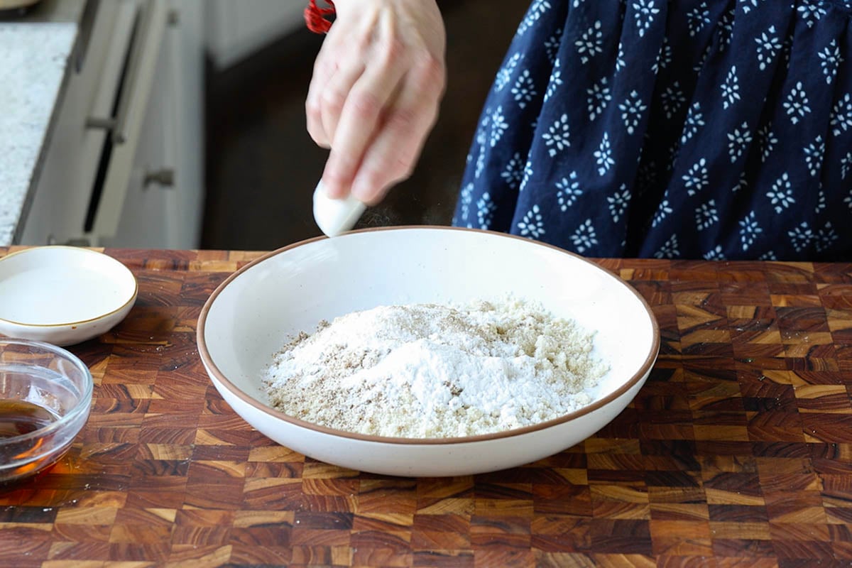 adding dry ingredients to a bowl