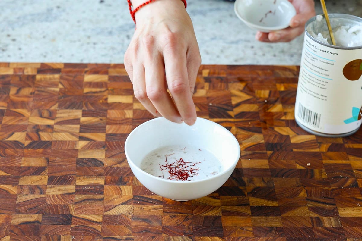 adding saffron to warm coconut milk