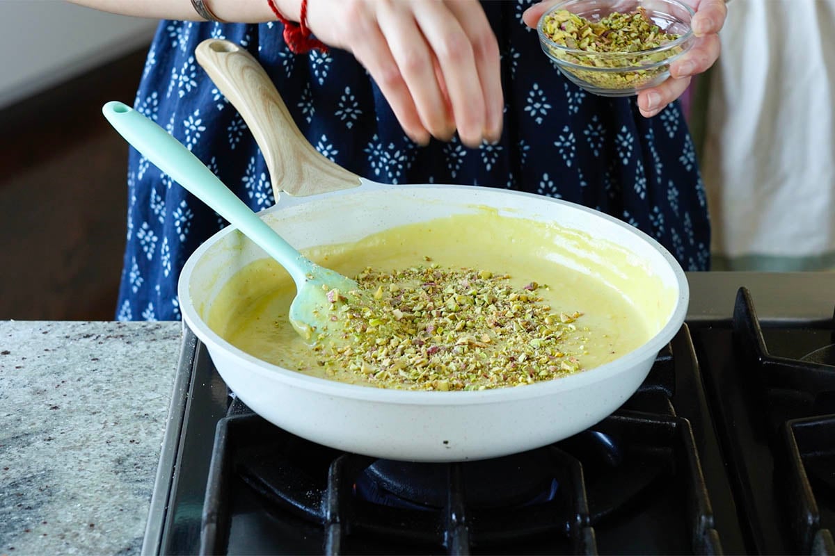 adding pistachios to the saffron cream