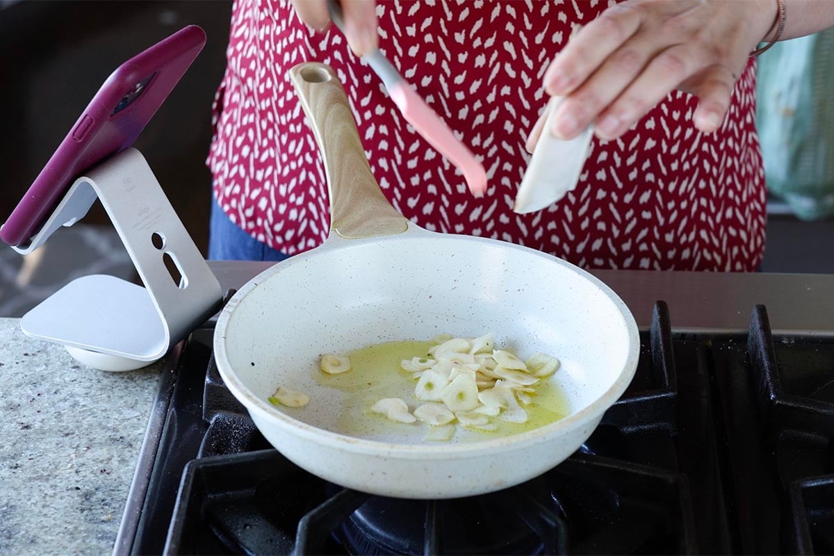adding garlic to the pan