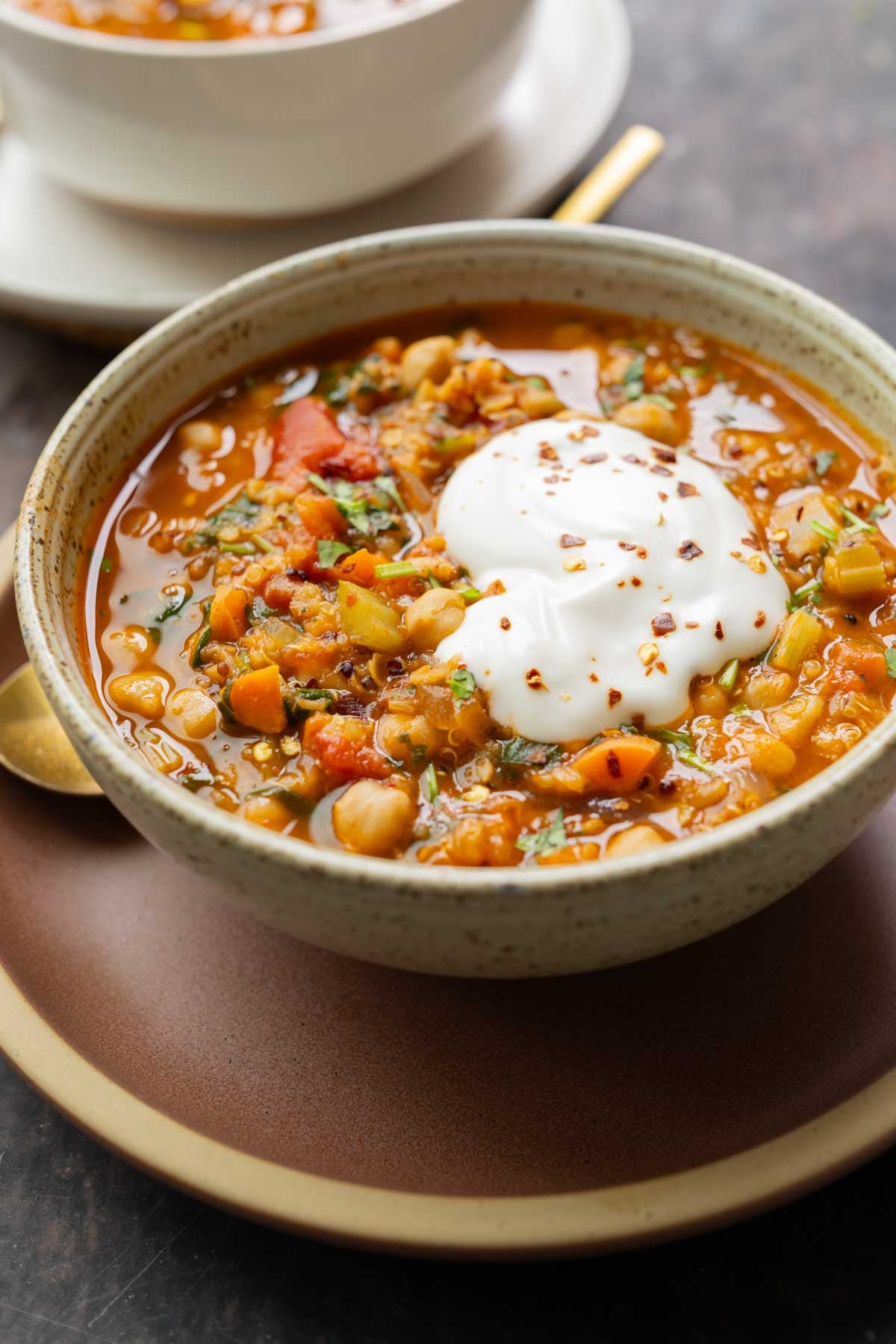 bowl of Moroccan harira garnished with yogurt and red pepper